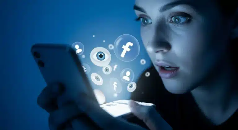 Pessoa olhando para o celular com expressão de surpresa, enquanto ícones flutuantes do Facebook com olhos e perfis aparecem ao redor, simbolizando a ideia de descobrir quem espionou o perfil na rede social.