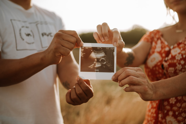 person holding a photo of a man and woman — Foto por Omar Lopez na Unsplash