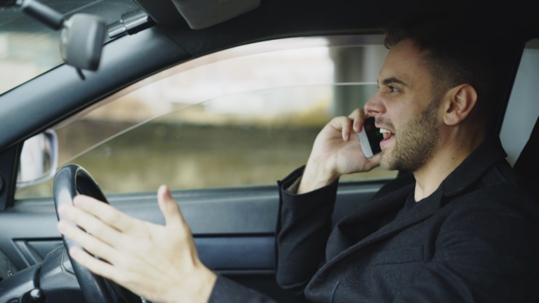 Man talking on phone while driving car — Foto por Vitaly Gariev na Unsplash